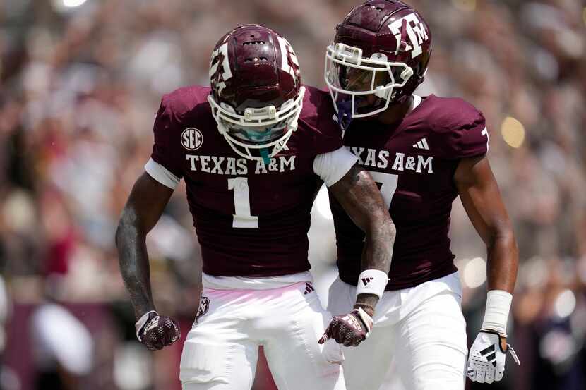 Texas A&M wide receiver Evan Stewart (1) reacts with teammate Moose Muhammad III (7) after...