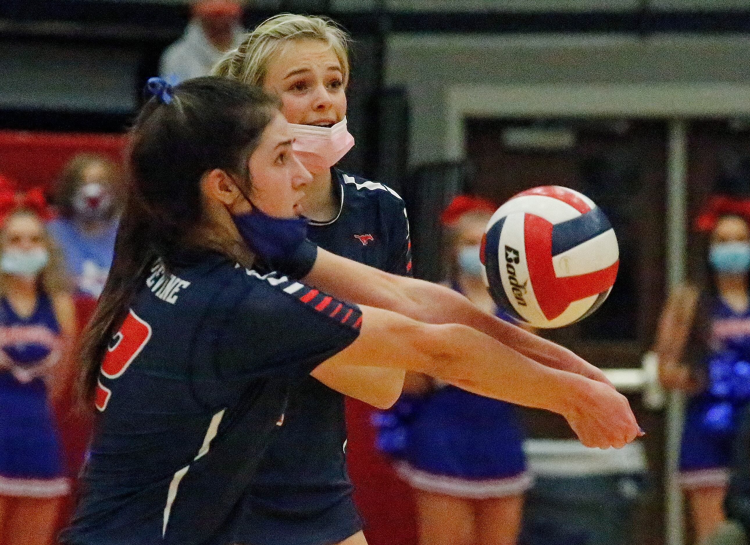 Grapevine High School outside hitter Janet Demarris (12) receives a serve in front of...