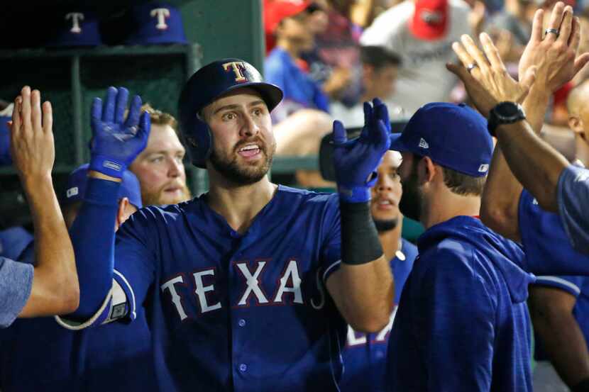 Texas Rangers third baseman Joey Gallo (13) is congratulated by teammates in the dugout...