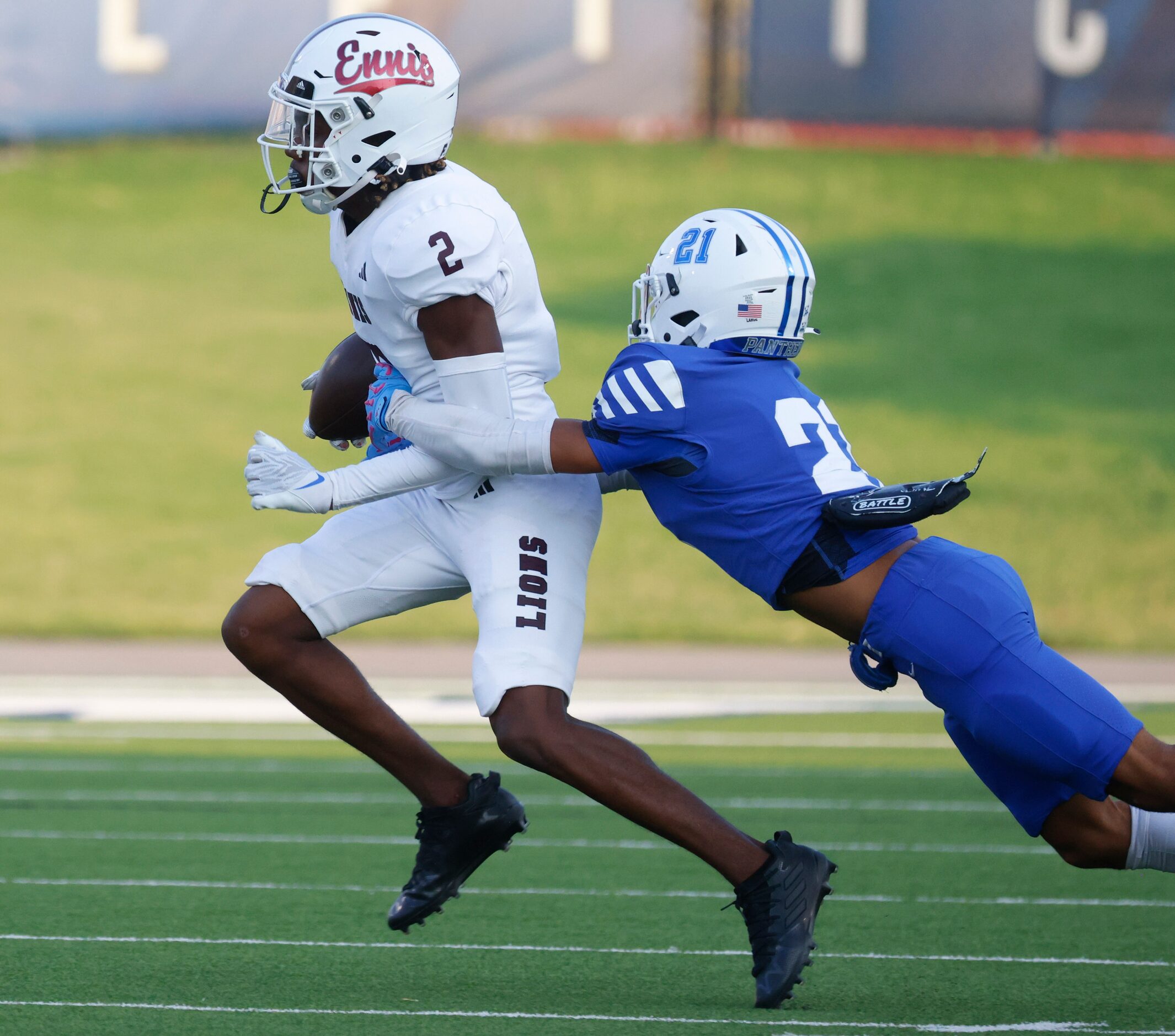 Ennis’ Lamarion McGowan (left), gets tackled by Midlothain’s Roman Parham (21) during the...