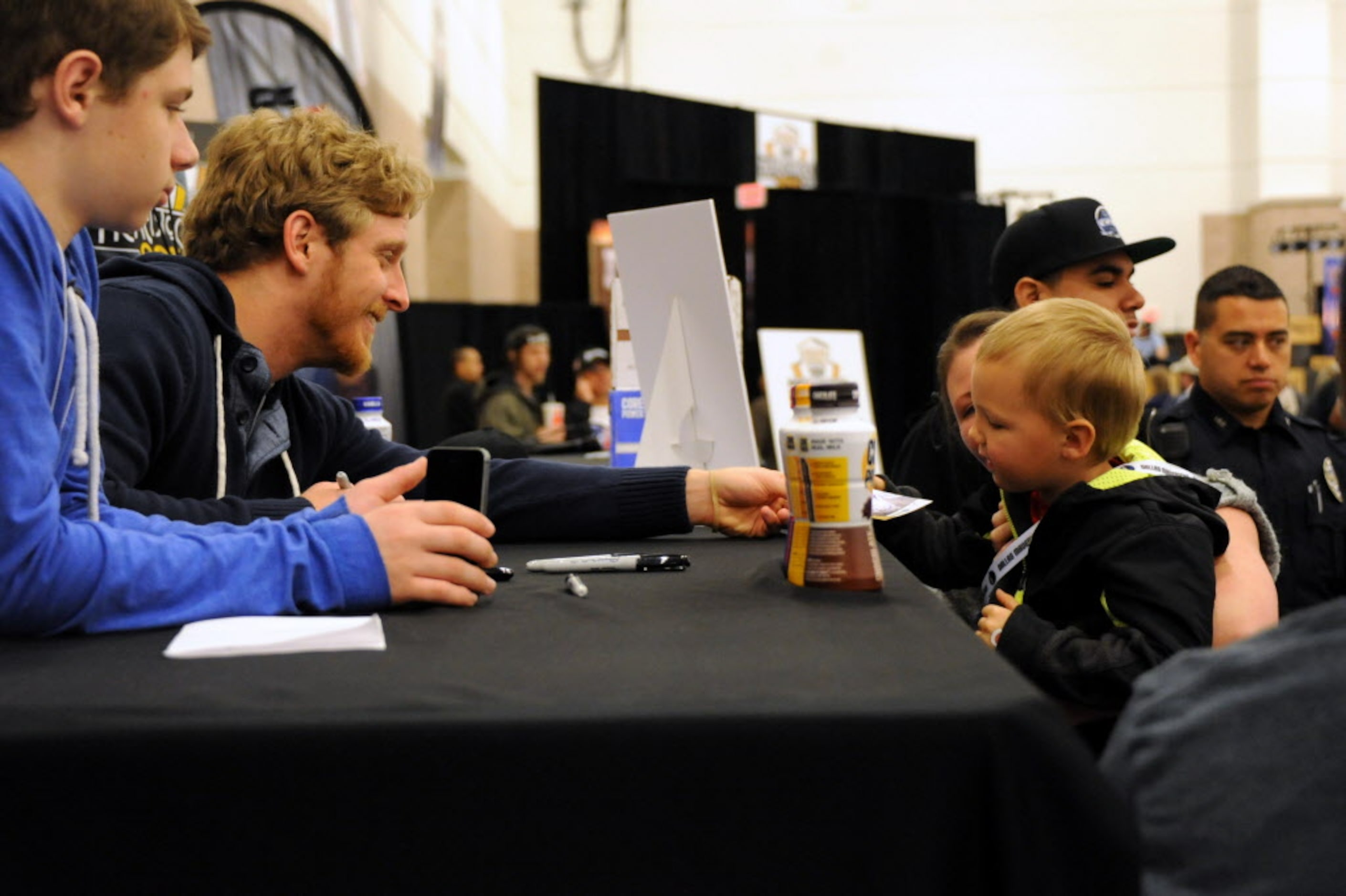 Dallas Cowboys wide receiver Cole Beasley hands a signed picture to a little fan at The...