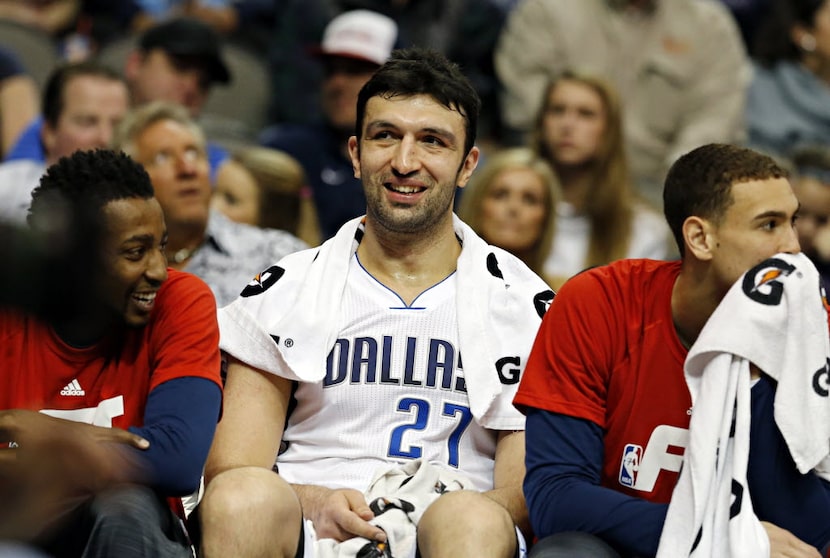 Dallas Mavericks center Zaza Pachulia (center) is all smiles on the bench after his...