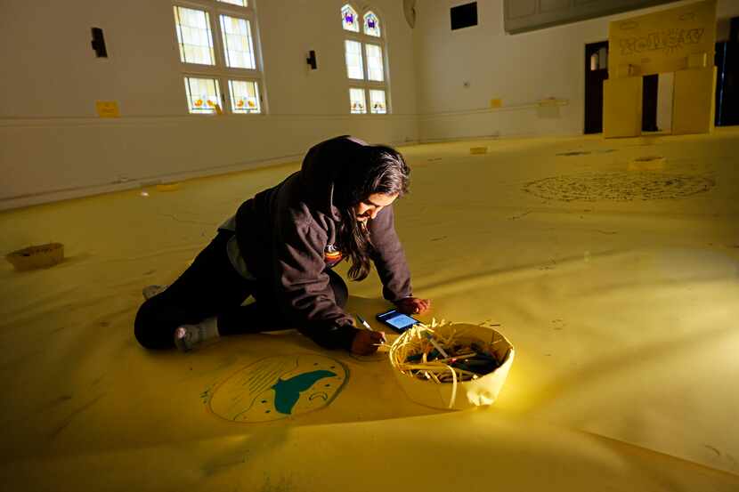 Attendee Yumna Moazzam of Dallas creates her artwork at  “YELLOW,” an interactive paper...