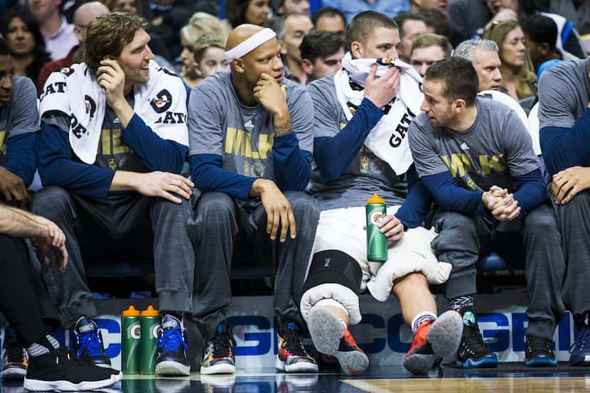 Dallas Mavericks forward Chandler Parsons (25) sits on the bench with his knees wrapped...