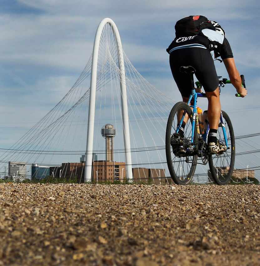A cyclist makes his way along a path on the levee off of Canada Drive in West Dallas. 