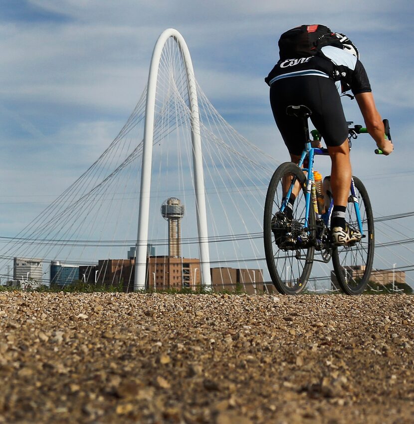 A cyclist makes his way along a path on the levee off of Canada Drive in West Dallas. 