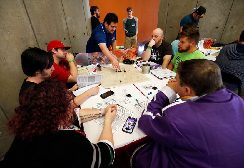 People gathered around a game table to play Dungeons and Dragons.