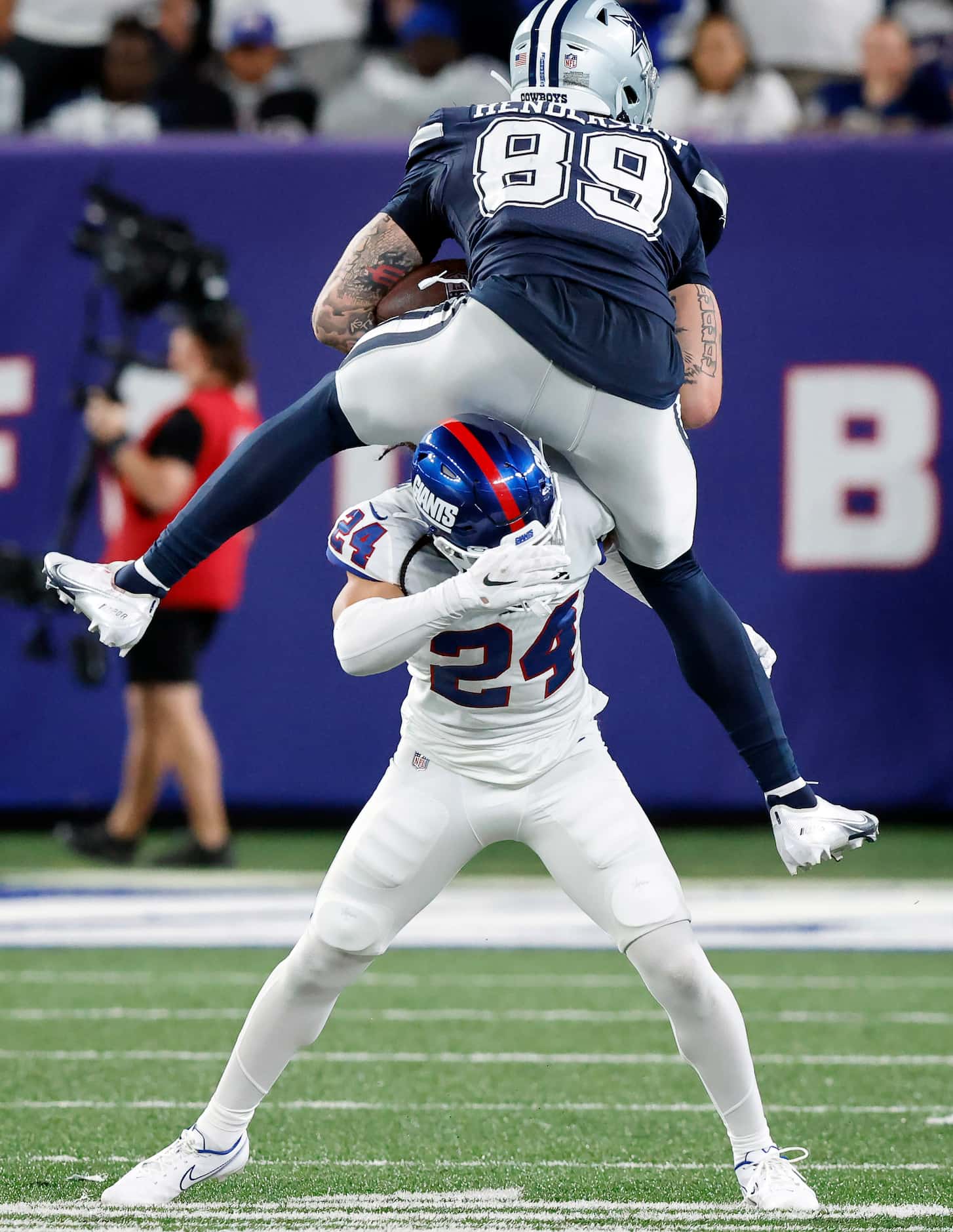 Dallas Cowboys tight end Peyton Hendershot (89) hurdles New York Giants safety Dane Belton...