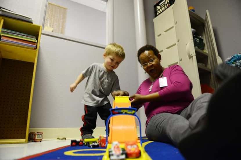
Catherine Wright, child specialist, plays with Jaxon Kendall, 2, while his mother, Sara,...