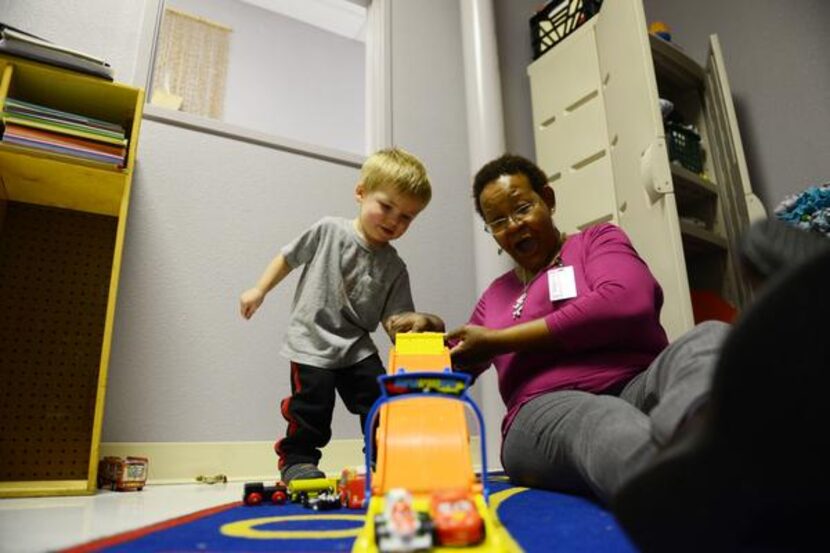 
Catherine Wright, child specialist, plays with Jaxon Kendall, 2, while his mother, Sara,...