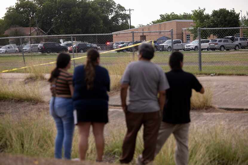 Neighbors watch as the scene is investigated after the shooting at Robb Elementary School in...