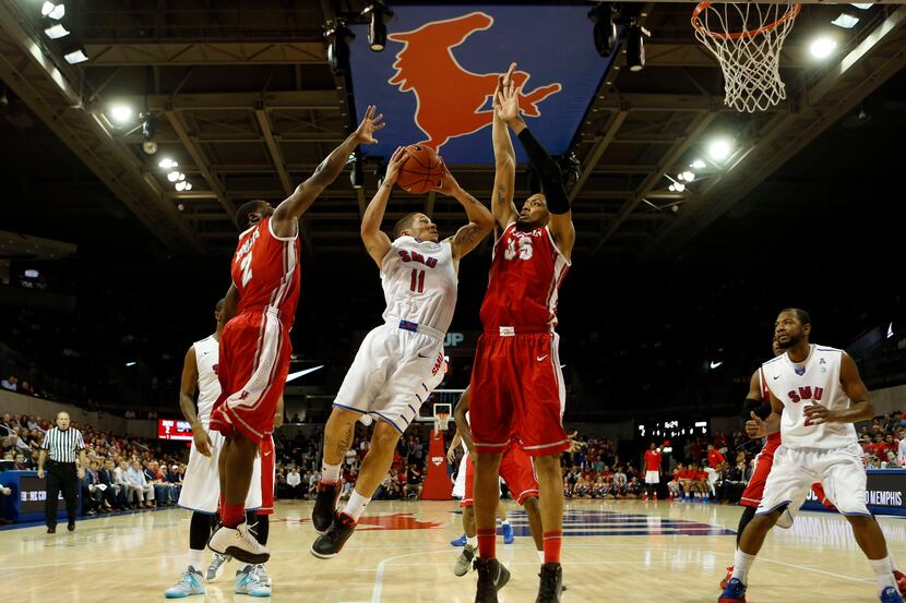 Southern Methodist Mustangs guard Nic Moore (11) attempts to split defenders Houston Cougars...