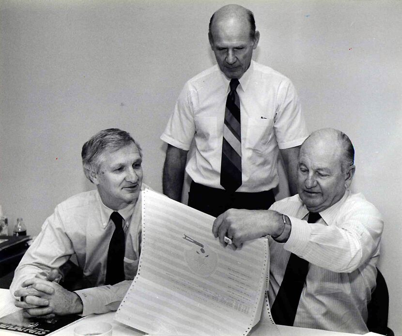 Dallas Cowboys officials Gil Brandt (from left), Tom Landry and Tex Schramm look over their...