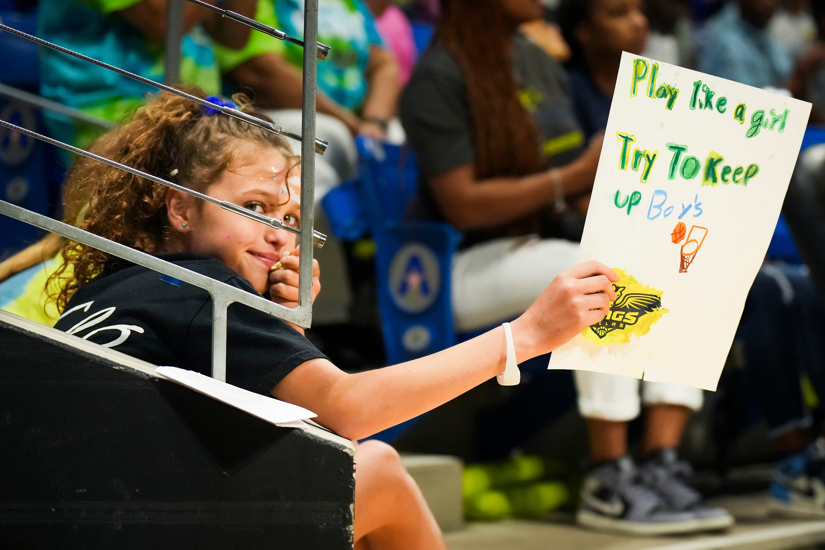 A fan holds a sign reading “Play like a girl” during the second half of a WNBA basketball...