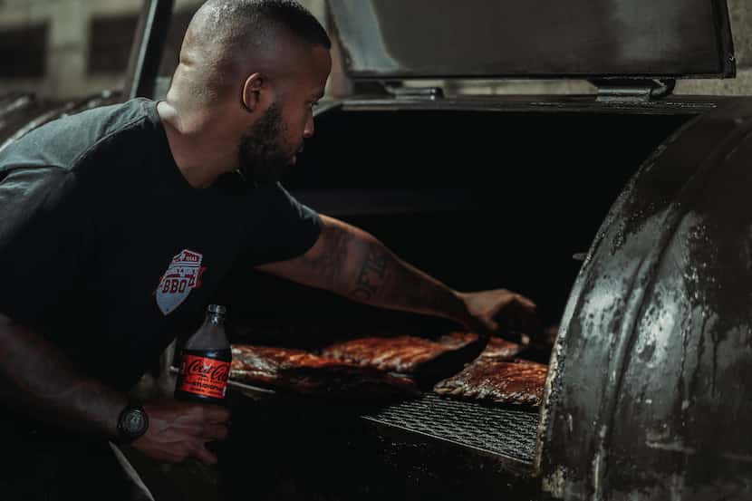 Smokey Joe’s Barbecue owner Kris Manning tends to meat on a grill.