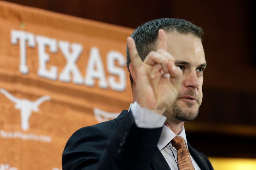 Tom Herman throws up the Hook 'Em Horns sign at his introductory news conference in...