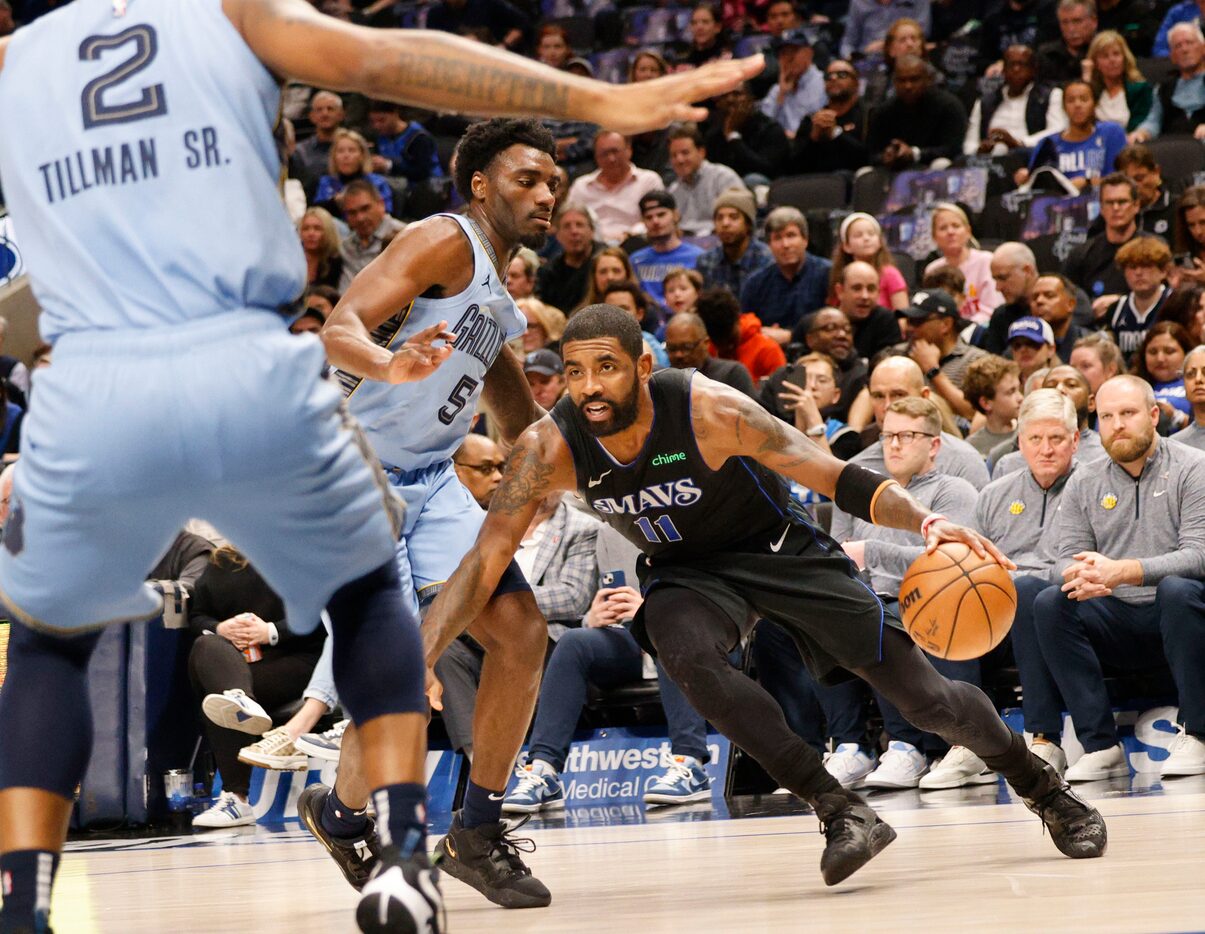 Dallas Mavericks guard Kyrie Irving (11) tries to drive past Memphis Grizzlies guard Vince...