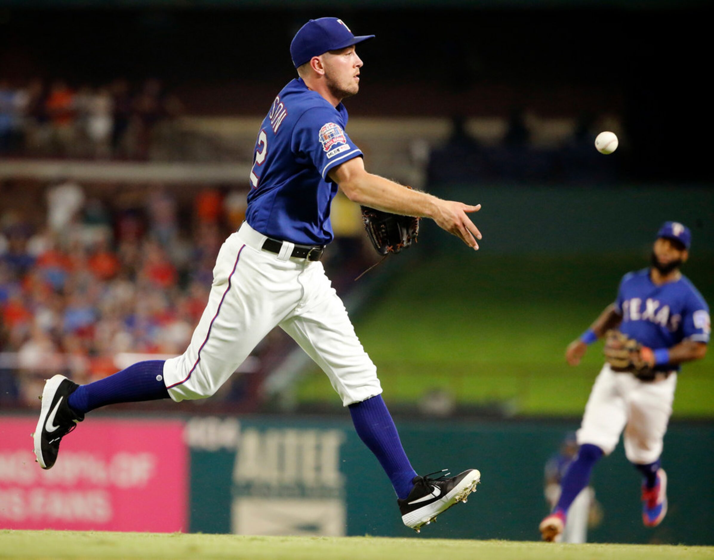 Texas Rangers starting pitcher Adrian Sampson (52) fields an infield hit and tosses it to...