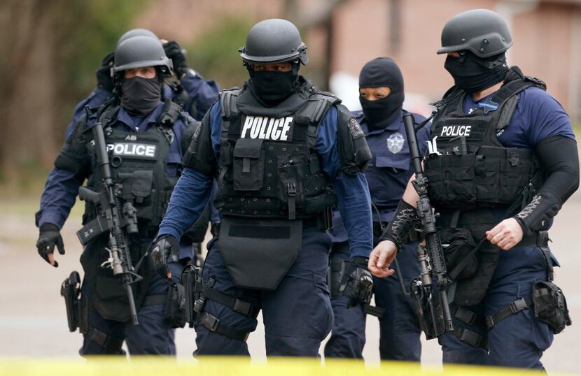 Dallas police and SWAT team members respond to a person who was barricaded inside a home...