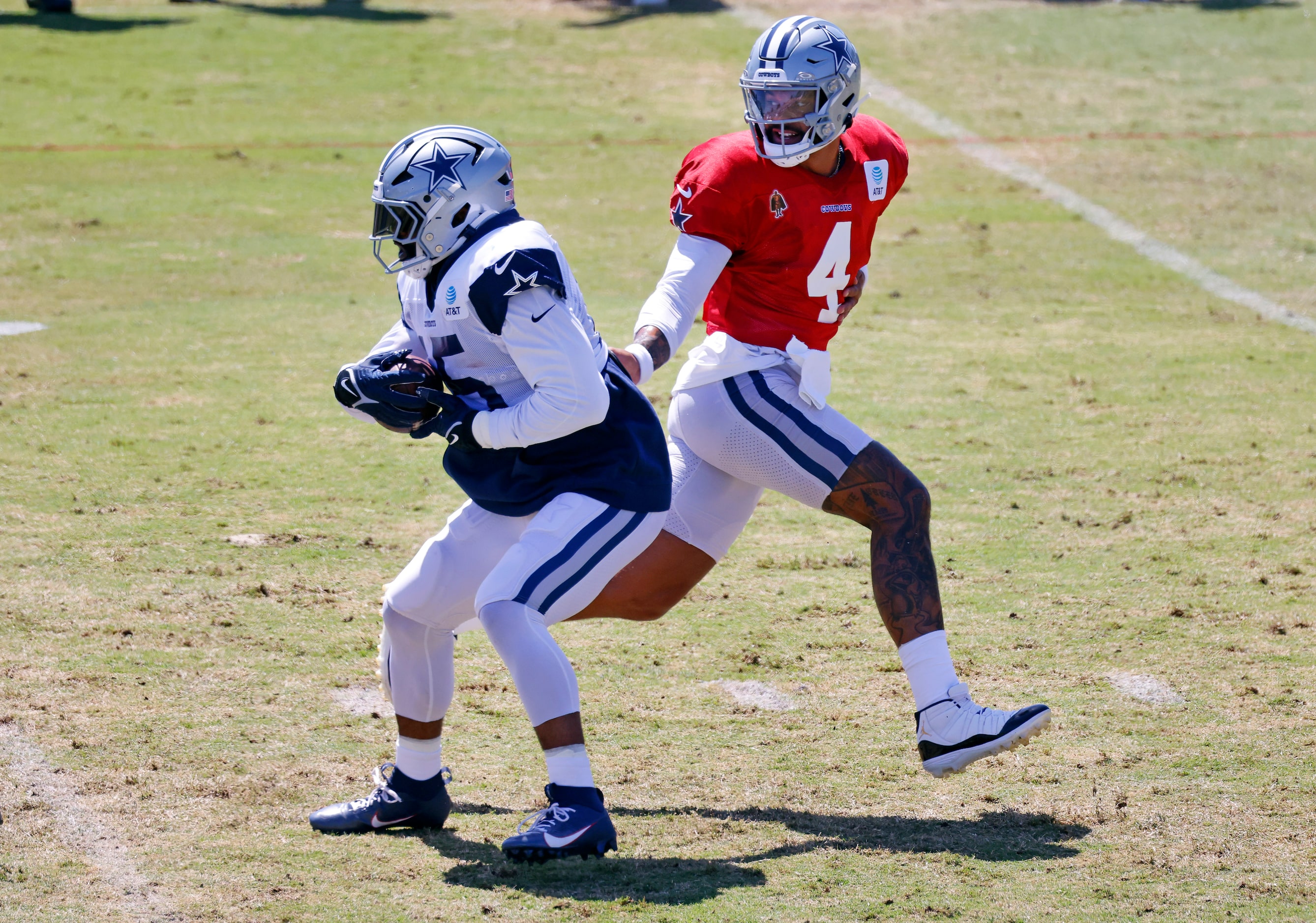 Dallas Cowboys quarterback Dak Prescott (4) hands the ball off to running back Ezekiel...