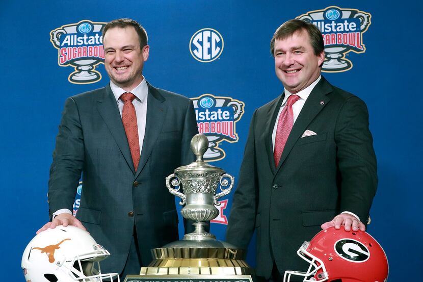 Georgia head coach Kirby Smart, right, and Texas head coach Tom Herman laugh during their...