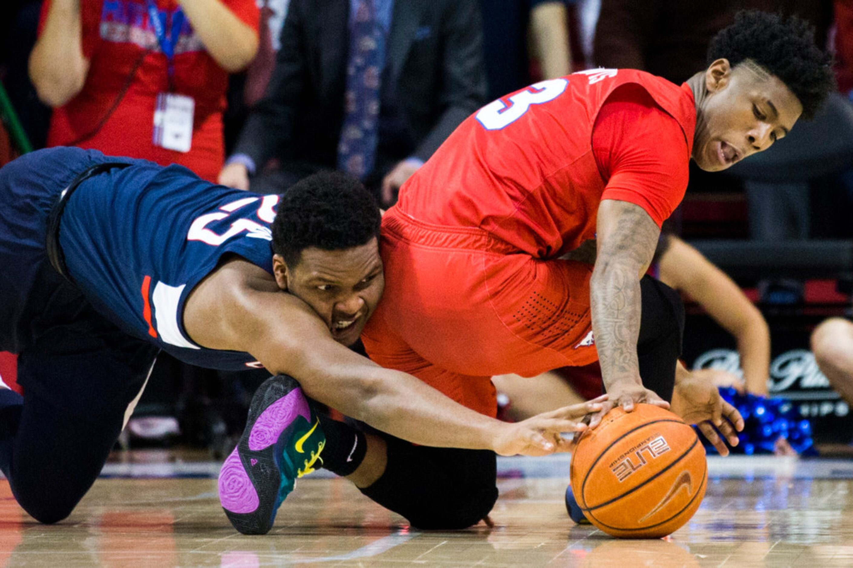 SMU guard Kendric Davis (3) and Connecticut center Josh Carlton (25) reach for a loose ball...