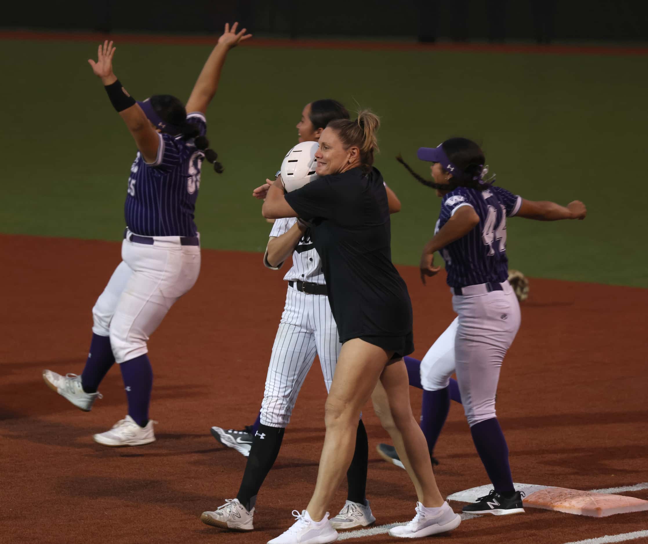 Denton Guyer assistant coach Lora Briggs, center, shares a consoling hug with infielder Erin...