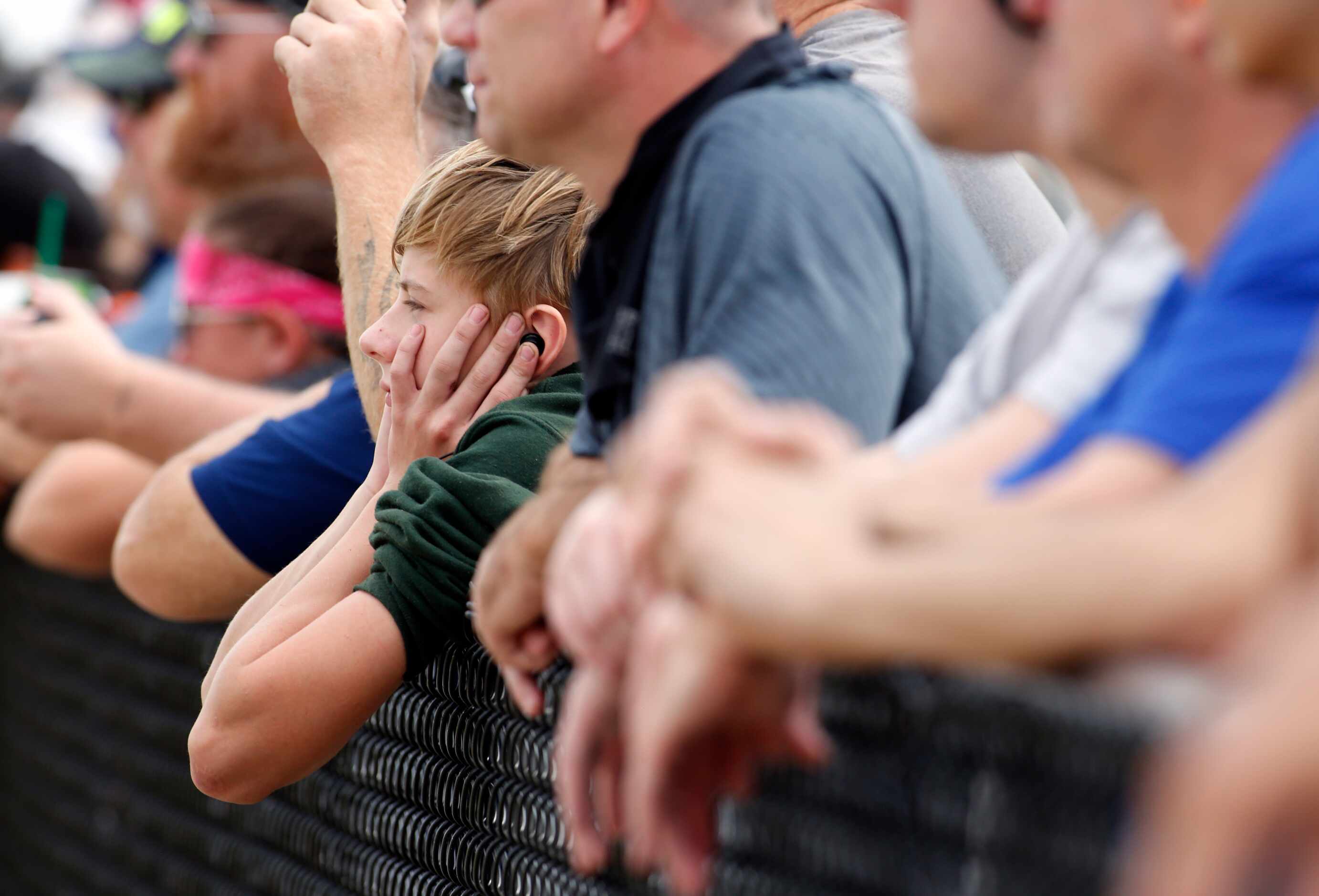 Zaithen Watkins guards his ears as racing fans look on at the start of a race in the funny...