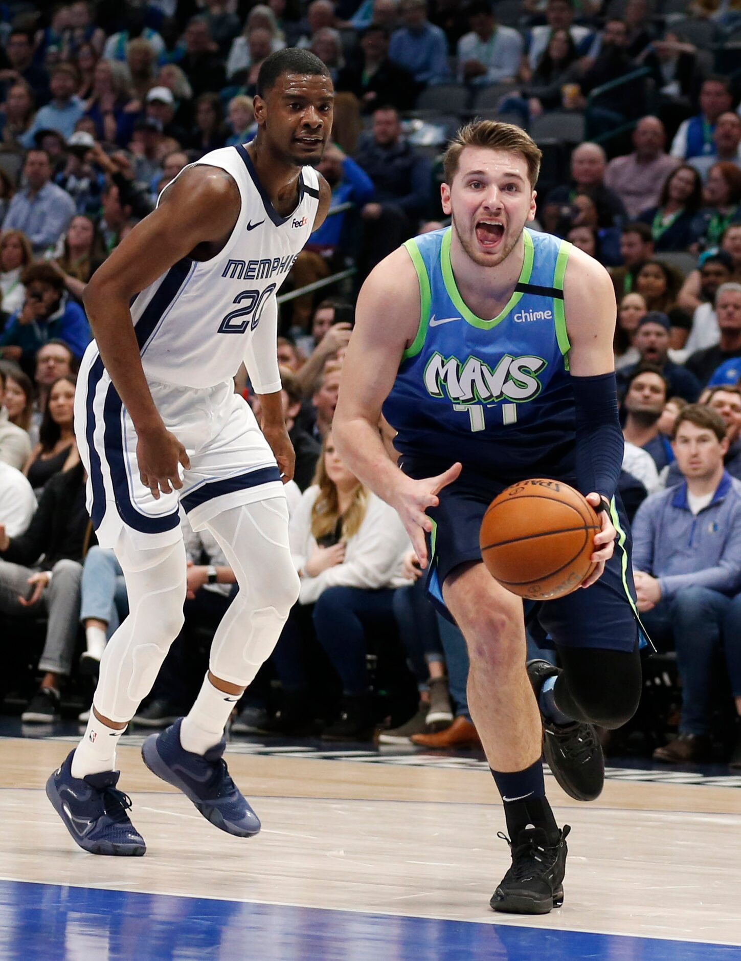 Dallas Mavericks guard Luka Doncic (77) goes up for a layup after passing by Memphis...