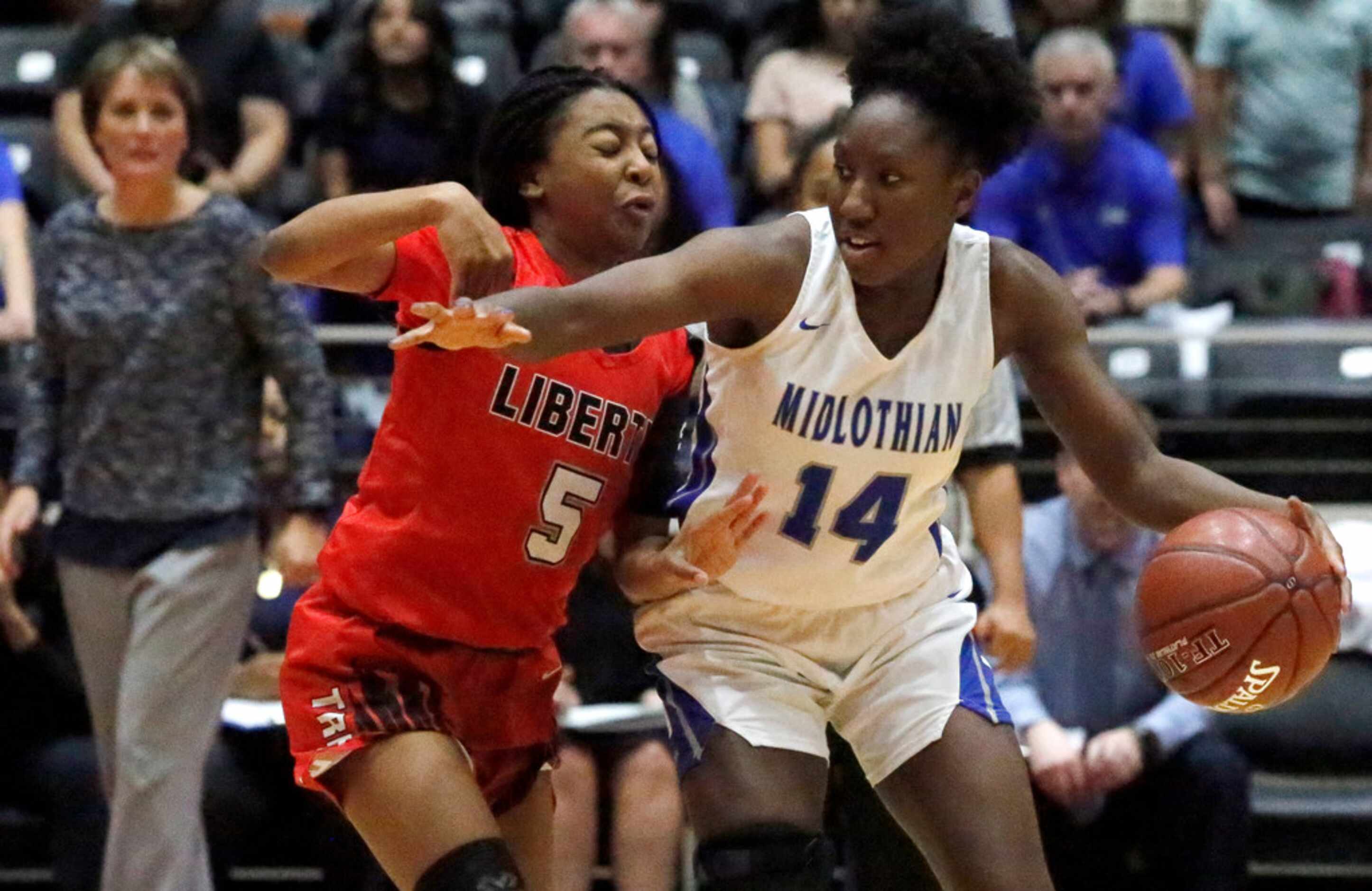 Midlothian High School guard Jerica Henderson (14) protects the ball while Frisco Liberty...