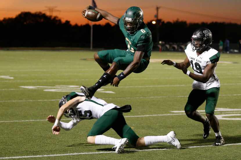 DeSoto Eagles Samari Collier (6) leaps over Mansfield Lake Ridge's Jaxson Lyness (15) as...