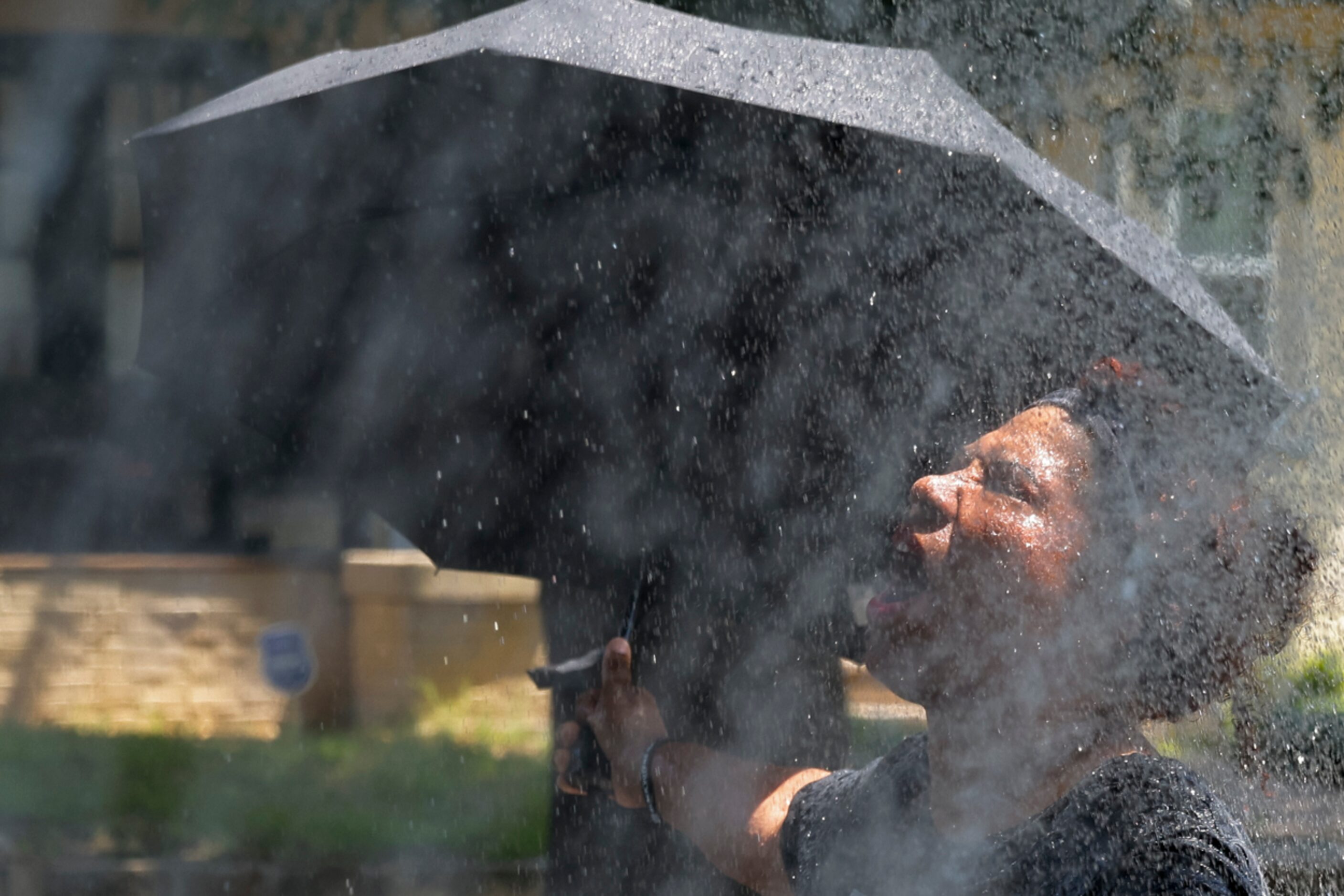 An attendee reacts while cooling off walking under hose water during Opal's Walk for Freedom...