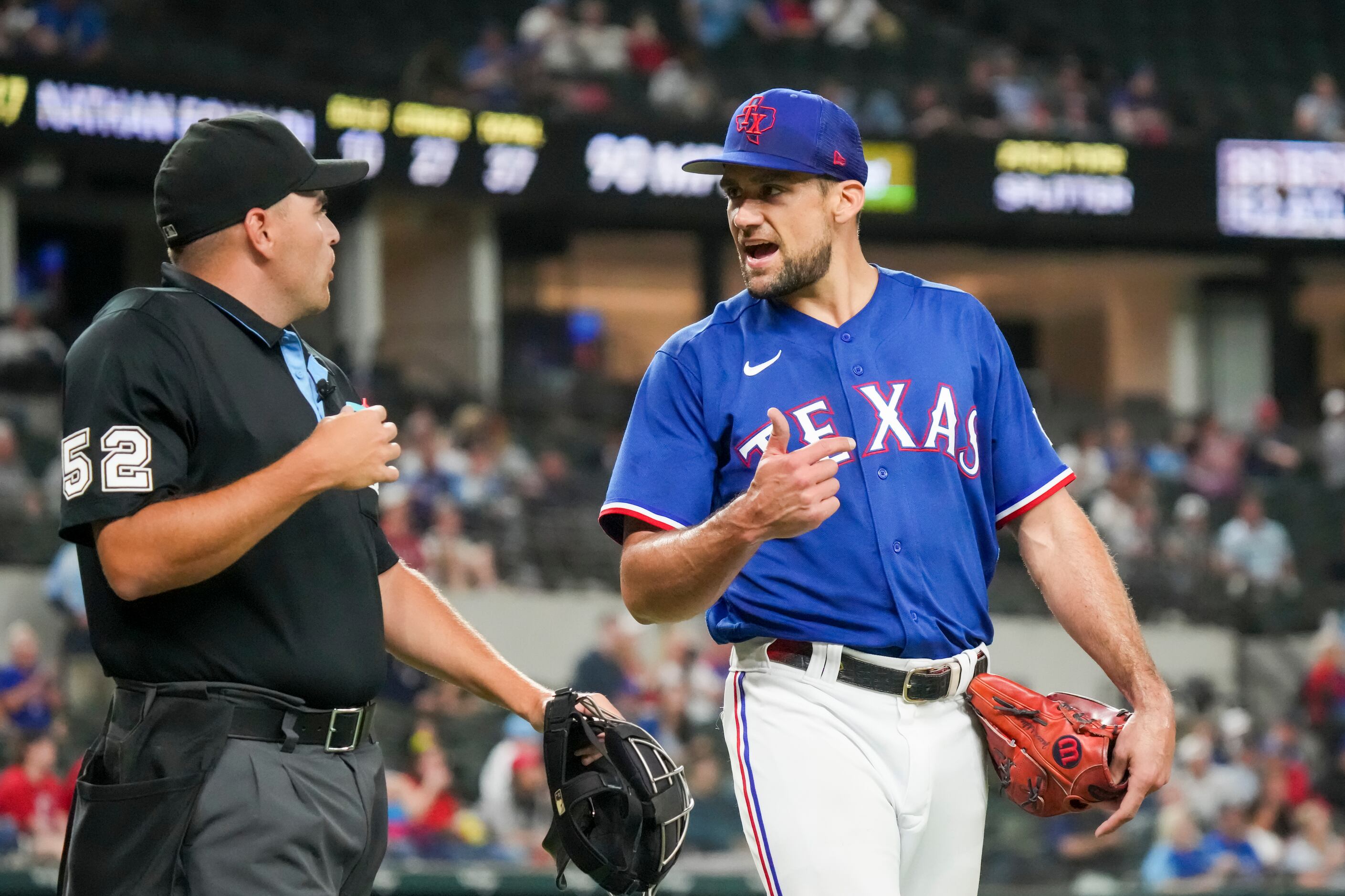 Texas Rangers starting pitcher Nathan Eovaldi (17) talks with umpire Jansen Visconti (52)...
