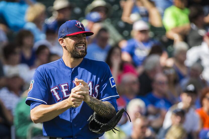 Texas Rangers pitcher Anthony Ranaudo rubs down a new ball while pitching during a spring...