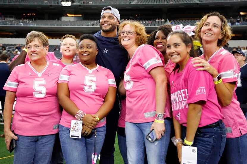 Dallas Cowboys quarterback Dak Prescott (4) poses for photos with Star Survivors (women who...