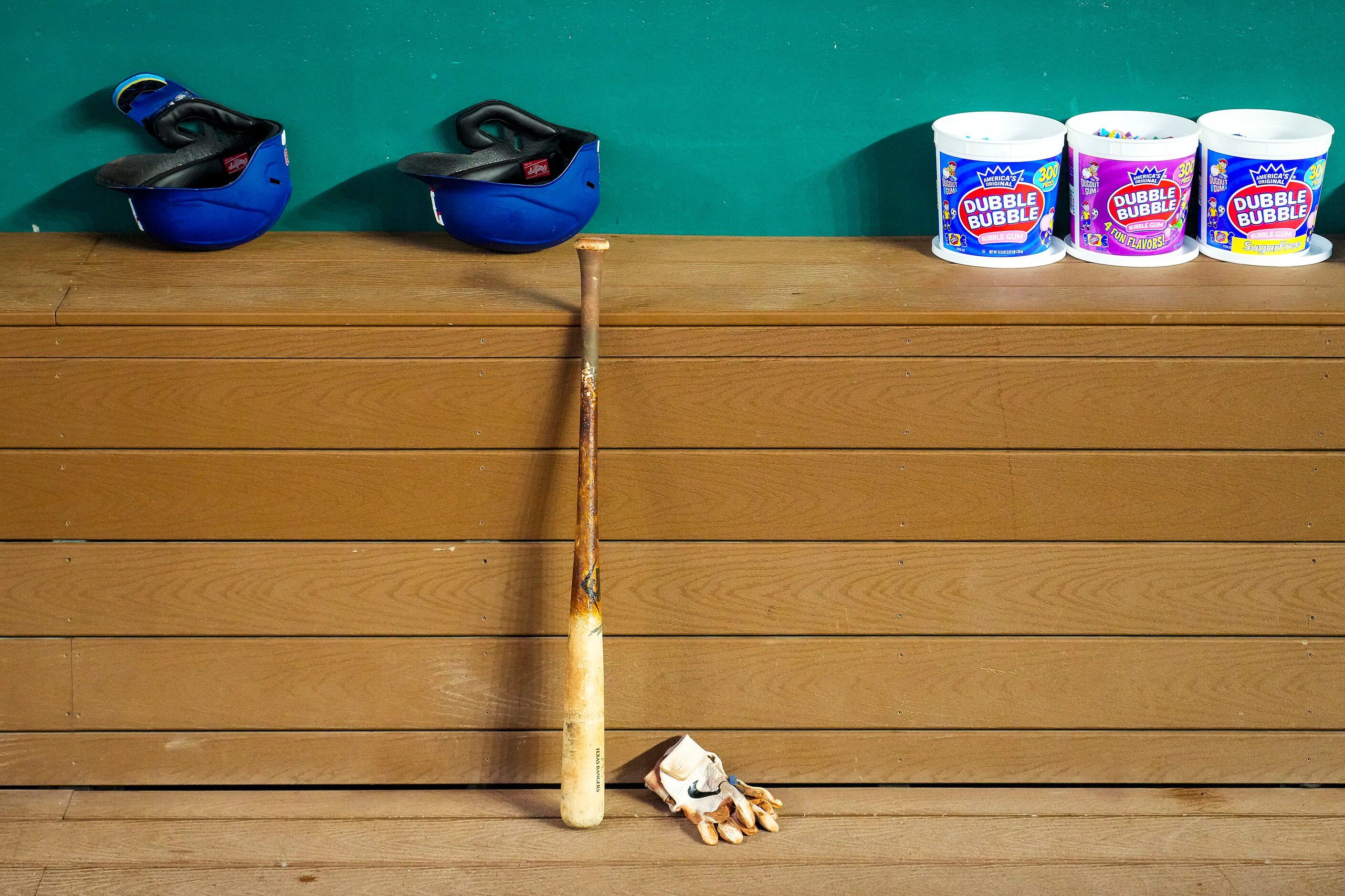 Bats, helmets and bubble gum sit in the Texas Rangers dugout before the team’s home opener...