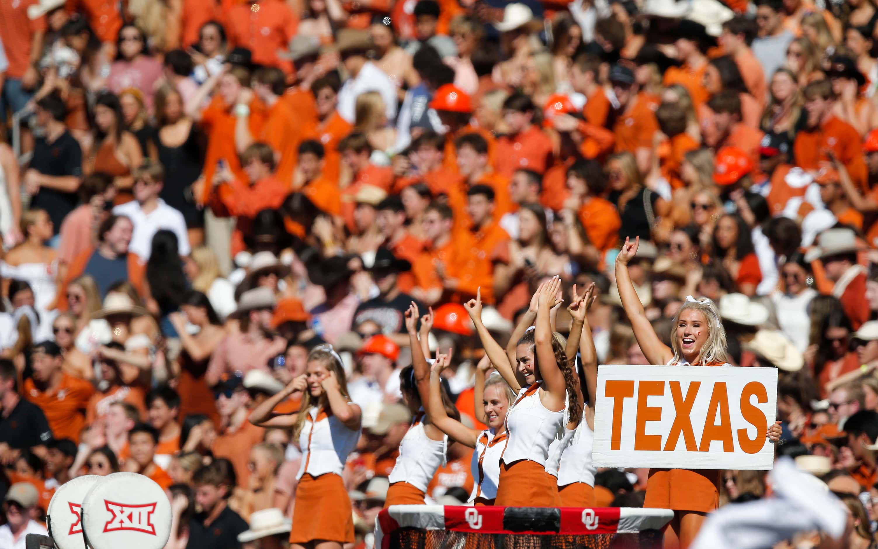 Texas cheerleaders lead fans in cheering for their team during the first half of an NCAA...