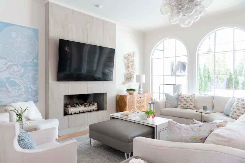 In this living space designed by Traci Connell, the TV is hung on a floor-to-ceiling...