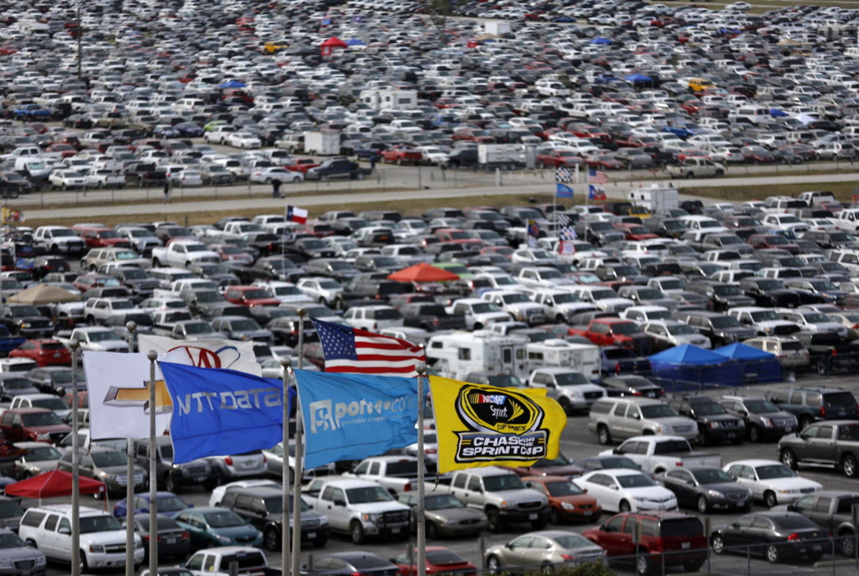 The Chase for the Sprint Cup flag flies before the field of parked cars outside the running...