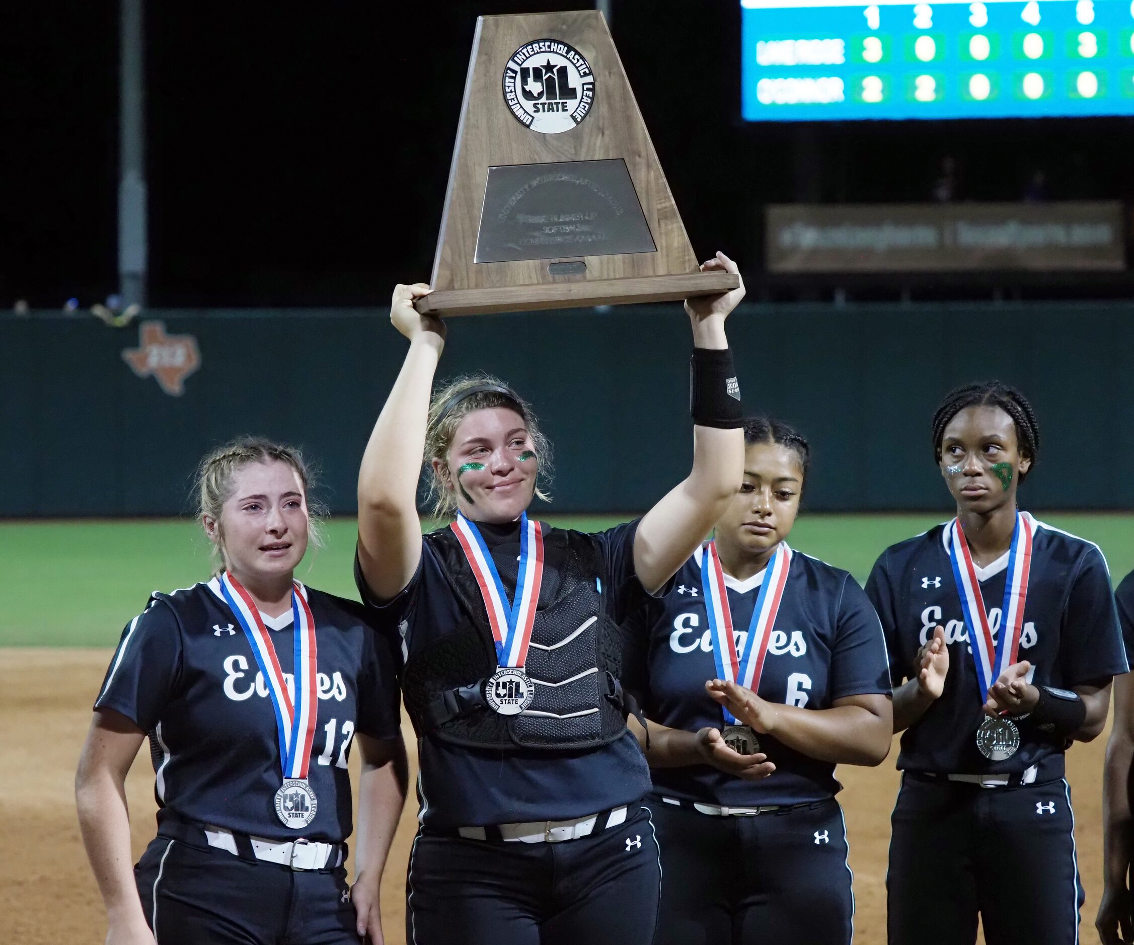 Mansfield Lake Ridge catcher Reign Brannon hoists the second place trophy after a defeat...