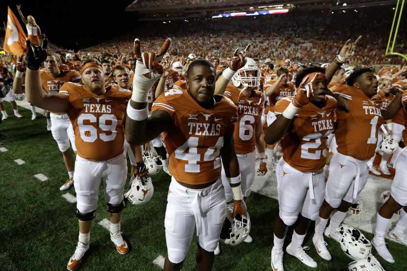Texas players gather for the school song following a NCAA college football game against...