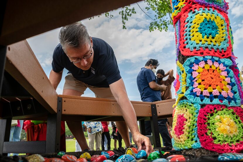 Bedford Mayor Michael Boyter places a painted rock with a positive message written on it at...