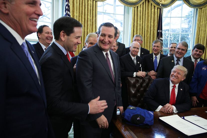 U.S. Sens. Marco Rubio (left) and Ted Cruz share a moment as President Donald Trump looks on...