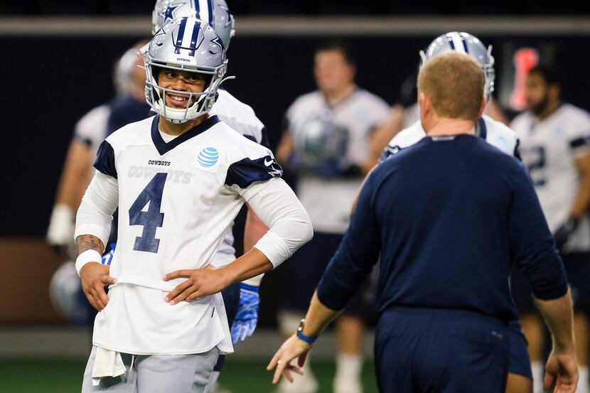 Dallas Cowboys quarterback Dak Prescott (4) smiles as he listens to head coach Jason Garrett...