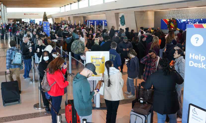 Travelers waited in lines to reach Southwest Airlines ticket counters at Dallas Love Field...