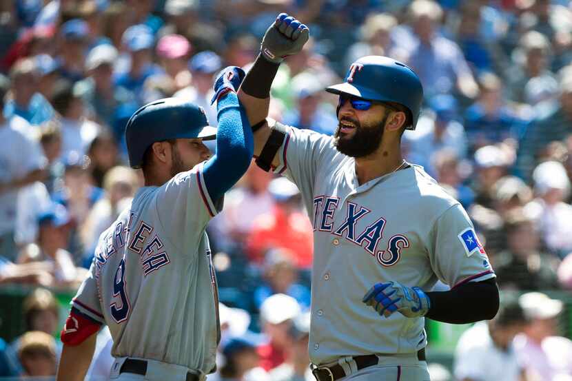 Texas Rangers' Nomar Mazara, right, celebrates his solo home run with teammate Isiah...