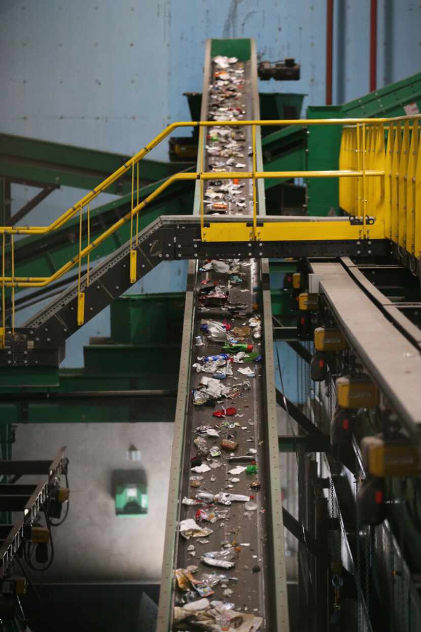 Recycled material moves on a conveyor belt to be sorted at the Dallas recycling facility....