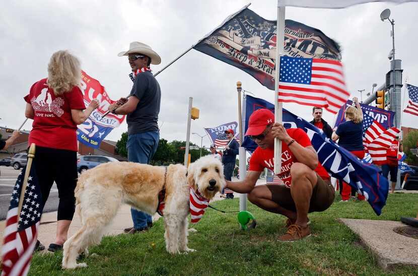 Billy Davis of Arlington (center) petted Bella, a dog owned by Justin Bennett (second from...
