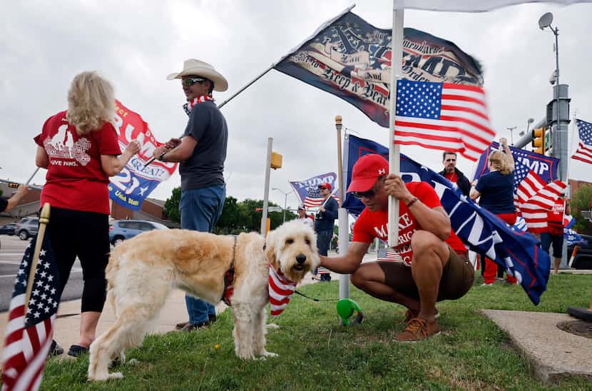 Billy Davis of Arlington (center) petted Bella, a dog owned by Justin Bennett (second from...