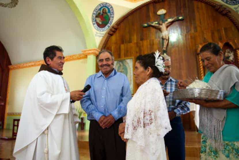 Francisca Santiago (der.) y su esposo Pablo Ibarra (centro) sonríen mientras intercambian...